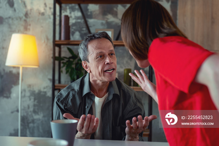 Shouting at wife. Angry mature man feeling extremely fierce while shouting at his emotional concerned wife