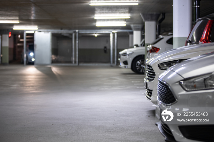 Underground parking. Cars parked in a garage with no people. Many cars in parking garage interior. Underground parking with cars (color toned image)