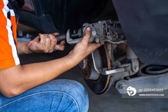 Male car mechanic examining brake disc.Car brake repairing in garage.Selective focus disc brake on car. Car disk brake system service concept