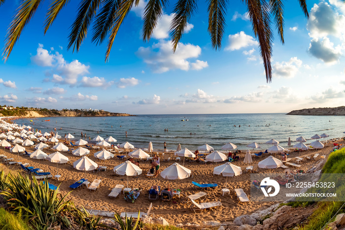 Tourists relaxing on the beach in the summer vacation. Peyia village, Paphos District, Cyprus