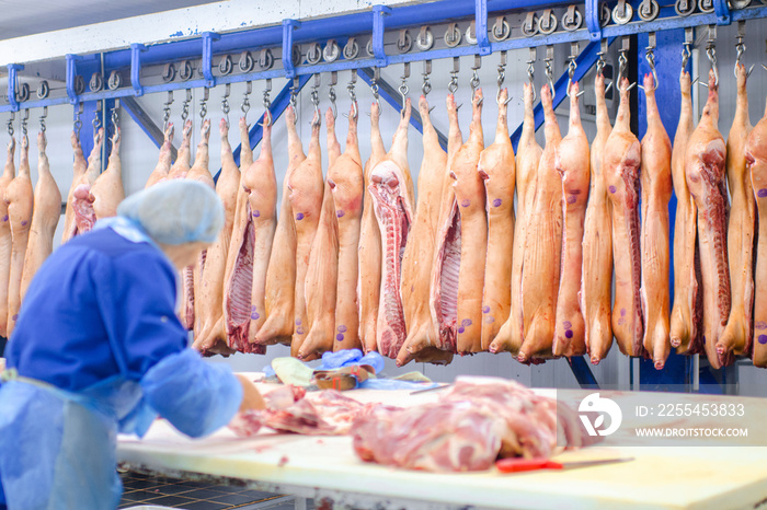 Meat deboning shop. Butcher. Butchers are cutting pork. Line of production of sausage delicacies