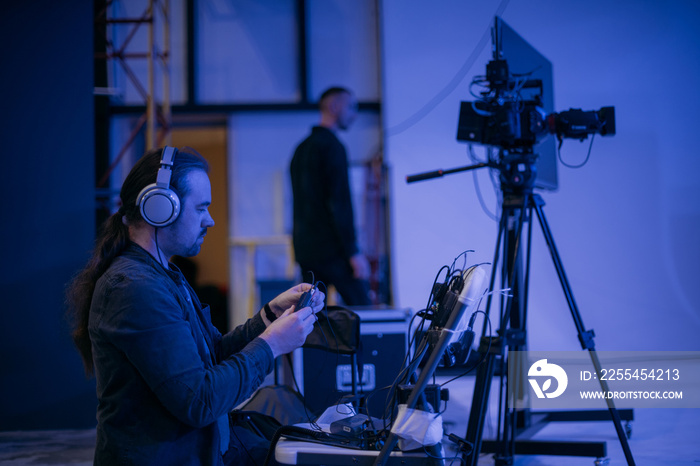 Sound engineer with a microphone on the set. A professional sound engineer at work on the filming of a movie, commercial or TV series.