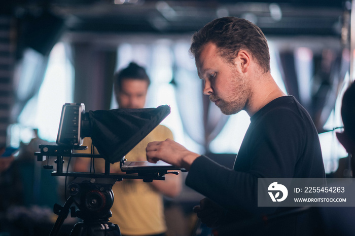 Director of photography with a camera in his hands on the set. Professional videographer at work on filming a movie