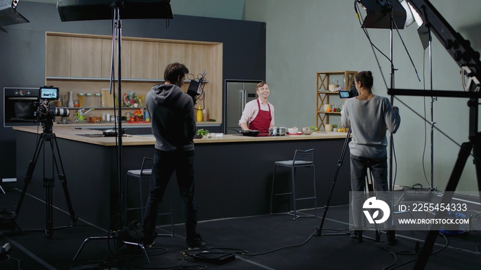 WIDE Behind the scenes of studio set, shooting TV television cooking show featuring celebrity chef, professional TV production