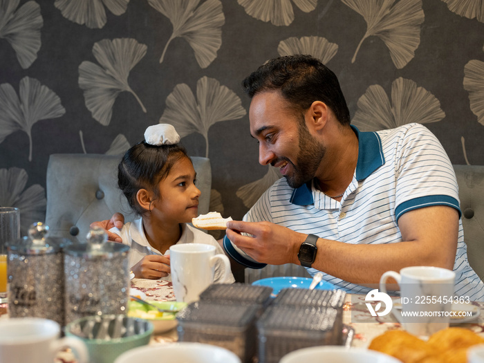 Father and son (6-7) eating meal at home