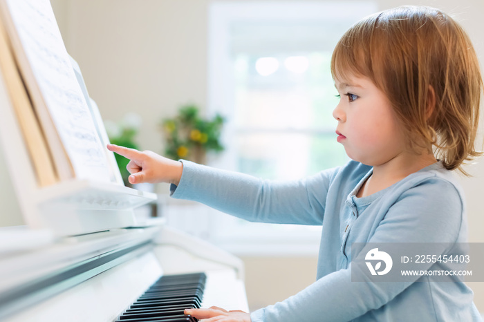 Toddler girl playing piano