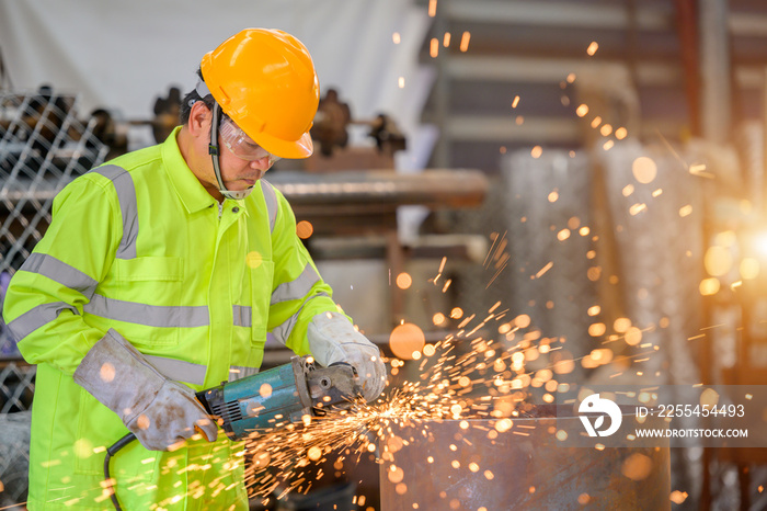 An industrial man who cuts a large number of sparked steel pipes in steel grinding.