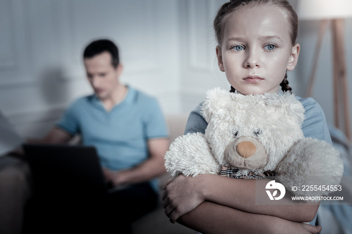 Sad thoughts. Lonely offended child thinking while standing in a room