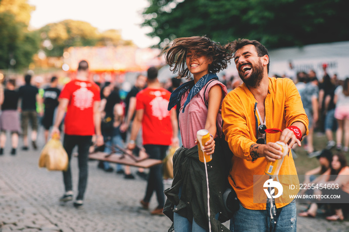 Young couple dancing at the music festival and spilling beer