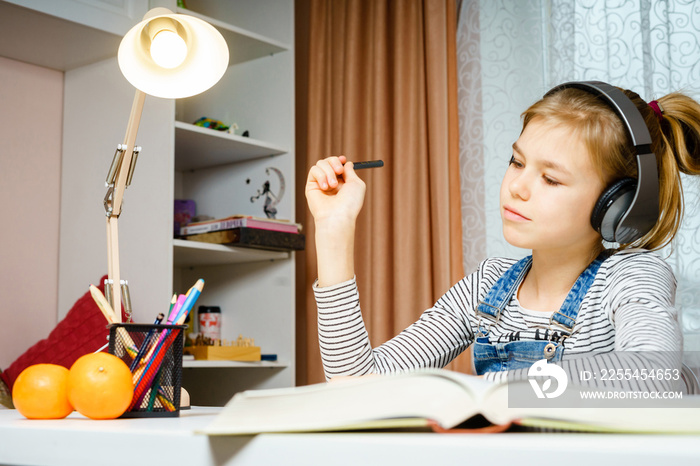 Teenage using headphones and doing school homework, learning and studing concept