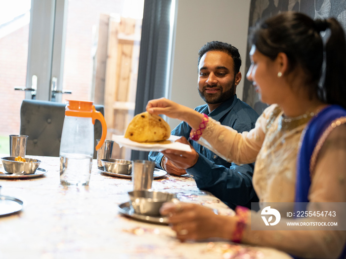 Couple in traditional clothing eating meal at home