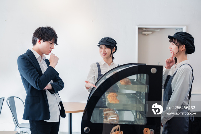 洋菓子店でお菓子を買うビジネスマン