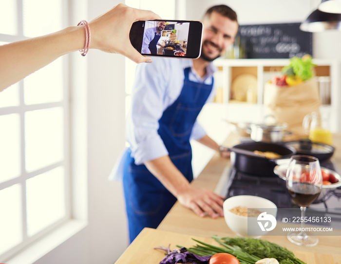 Portrait of handsome man filming cooking show or blog