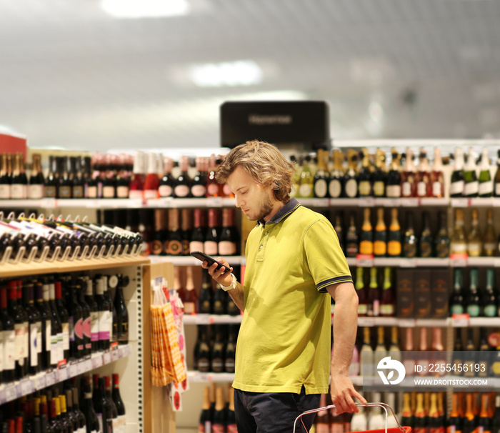 man choosing a wine, champagne at supermarket