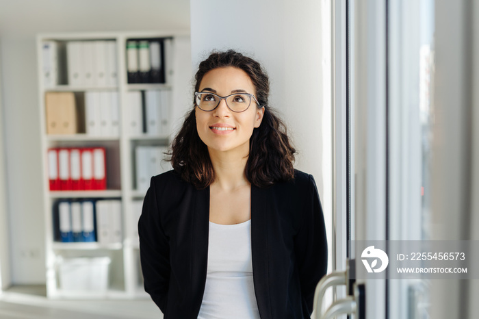 Young businesswoman standing deep in thought