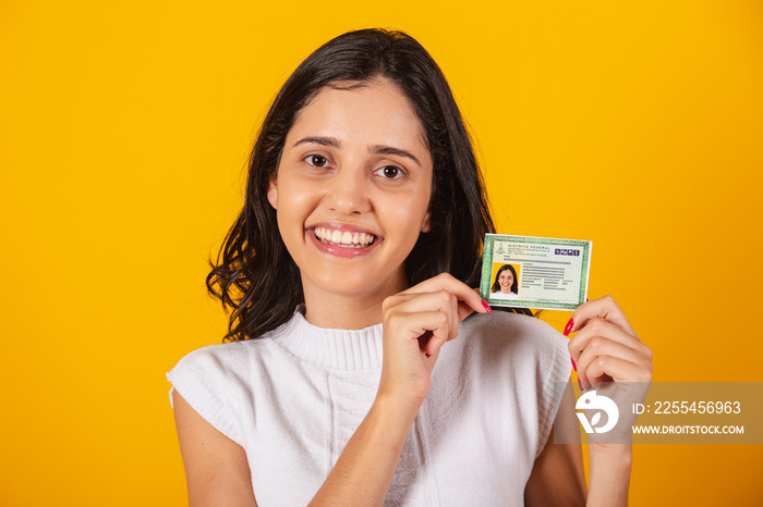 beautiful brazilian woman holding rg, brazilian identification document.