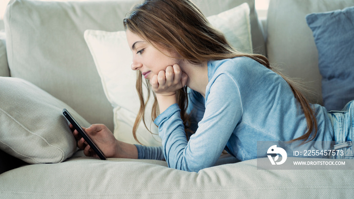 Young woman using mobile phone at home