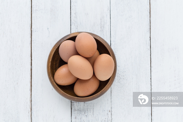 eggs in a wooden bowl on old wooden table top view