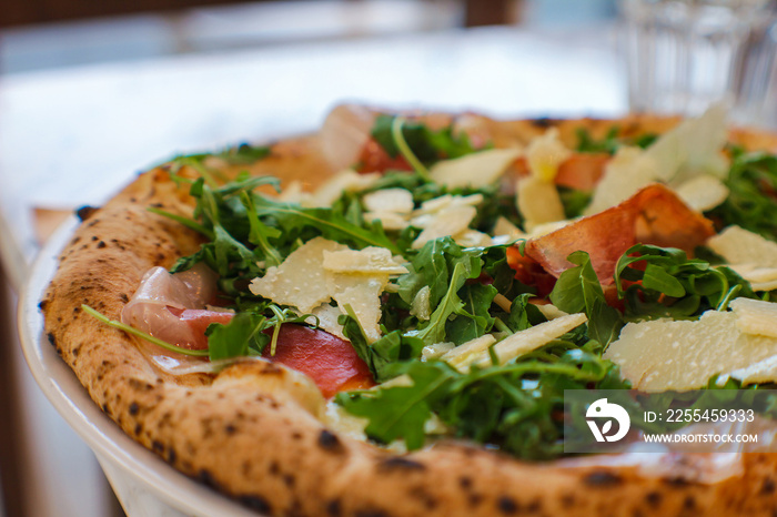 fior di latte pizza, extra virgin olive oil, raw Campano di Cillo, wild rocket and parmesan flakes in a traditional Italian pizzeria