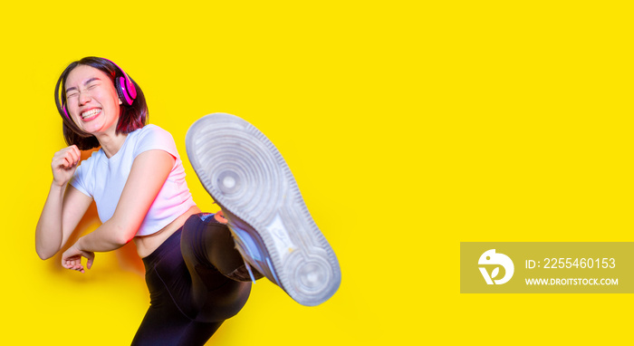 Asian young woman kick boxing on yellow background practicing sport laughing having fun isolated cropped banner