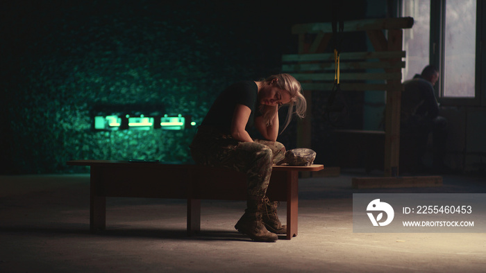 Exhausted female soldier resting on bench