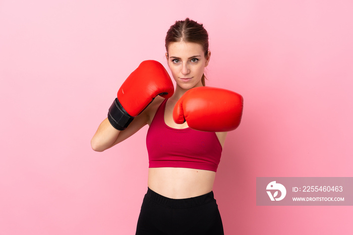 Young sport woman over isolated pink background with boxing gloves