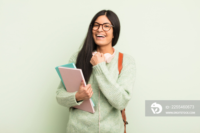 young pretty hispanic woman feeling happy and facing a challenge or celebrating. student concept