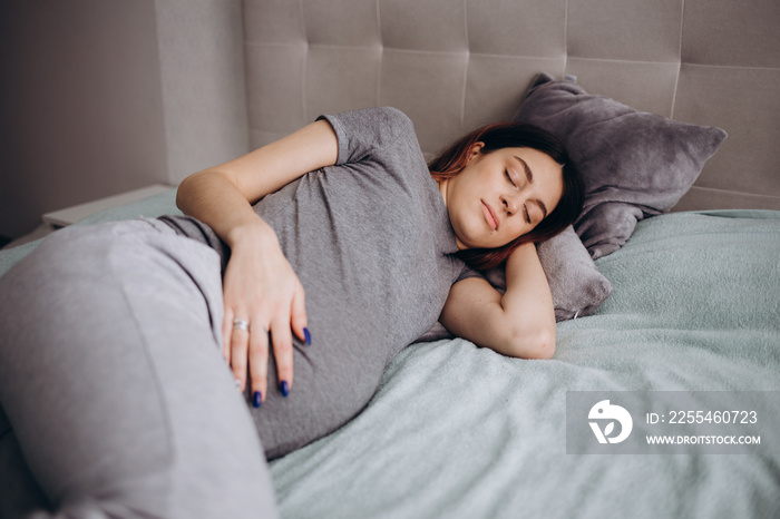 pregnancy, rest, people and expectation concept - happy pregnant woman sleeping in bed at home