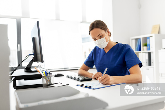 medicine, people and healthcare concept - female doctor or nurse wearing face protective medical mask for protection from virus disease with clipboard working at hospital