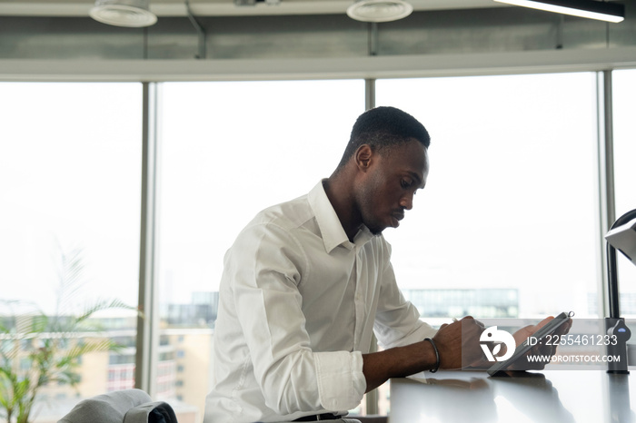 Young businessman using digital tablet in office