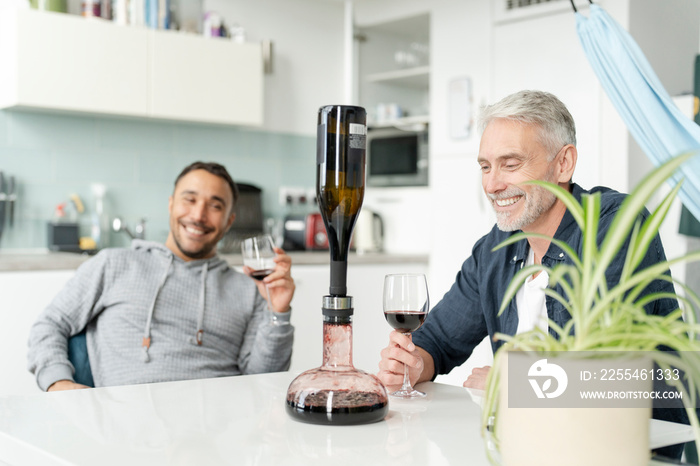 Male couple using wine breather decanter at home