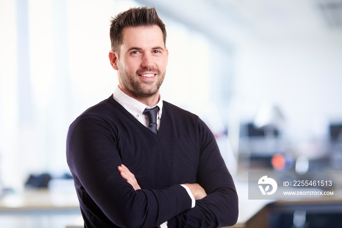 Businessman standing with folded arms in the office