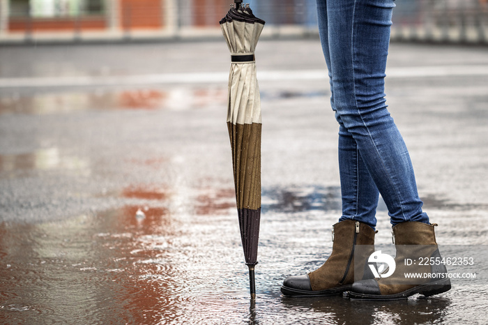 Woman with umbrella standing on city street during rain