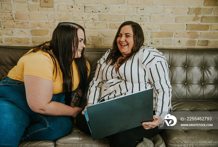 2 women look at laptop