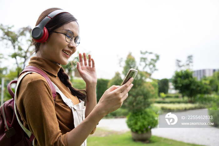 Attractive asian woman pleased positive casual say hi her friends on smartphone and enjoy fresh air in beautiful natural at park