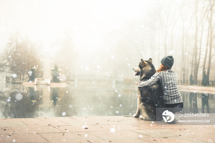 Image of young girl with her dog, alaskan malamute, outdoor