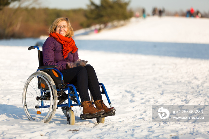 happy woman on wheelchair in the snow