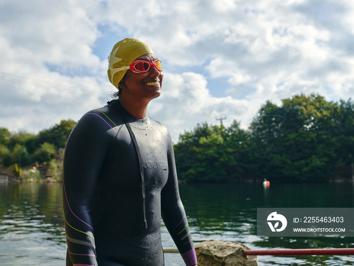 Woman in swimming cap and goggles standing in river