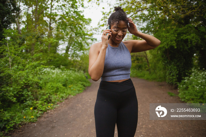 Young curvy woman with vitiligo talking on the phone in workout clothes