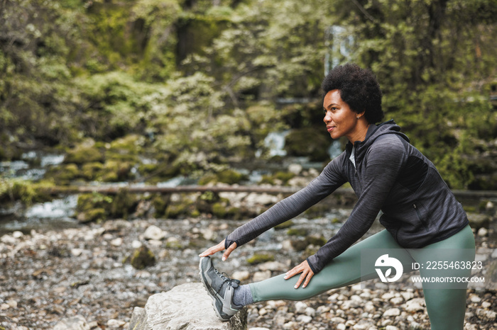 Black Woman Warming Up Before Jogging In Nature