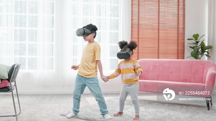 Portrait of enjoy happy kids using VR metaverse gaming technology in living room at home. Child smiling and having fun using glasses of technology virtual reality headset playing sport gaming