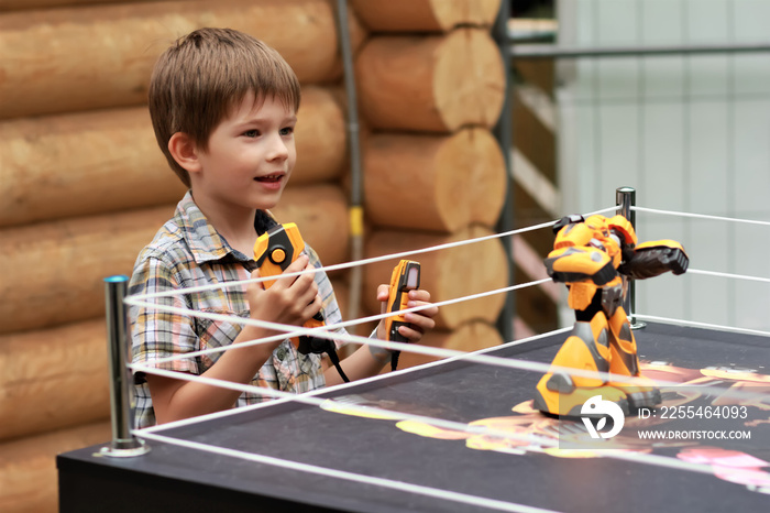 Boy playing battle fighting robot with remote control outdoors