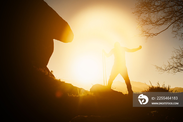 silhouette of man exercising with elastic bands on the mountain at sunset. healthy life style.