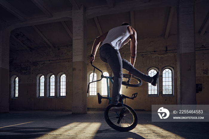 BMX stunts in a sunray indoor .