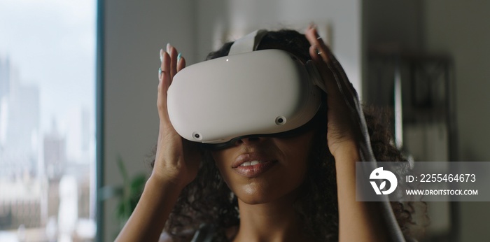 Attractive African American female puts on a VR virtual reality metaverse headset at home