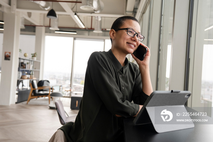 Woman using digital tablet and phone in office