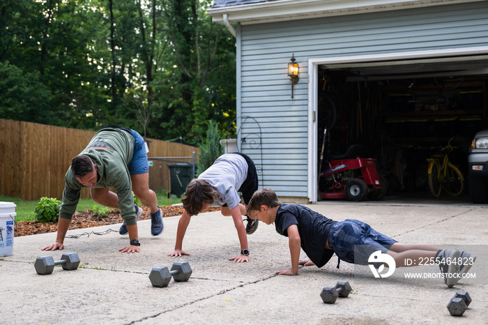 Air Force service member trains with his sons in a morning workout in preperation for a PT fitness test.