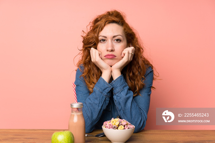 Redhead woman having breakfast cereals and fruit sad