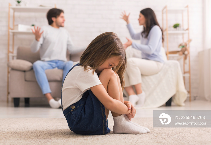 Family Conflict. Little girl crying after parents quarrel at home