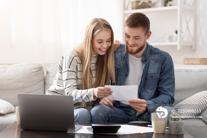 Happy married couple looking at personal finances at home